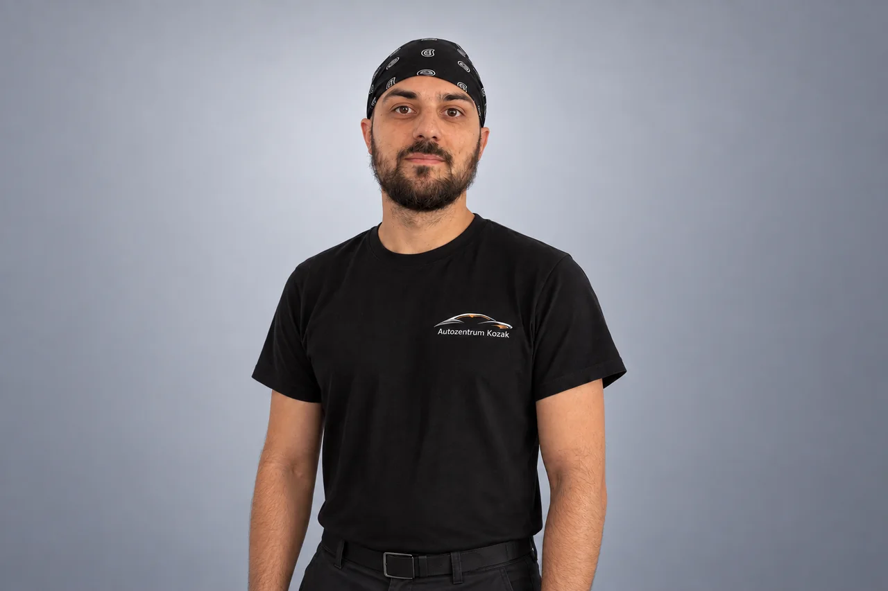 Mitarbeiterin oder Mitarbeiter des Autozentrums Kozak im schwarzen Firmenshirt