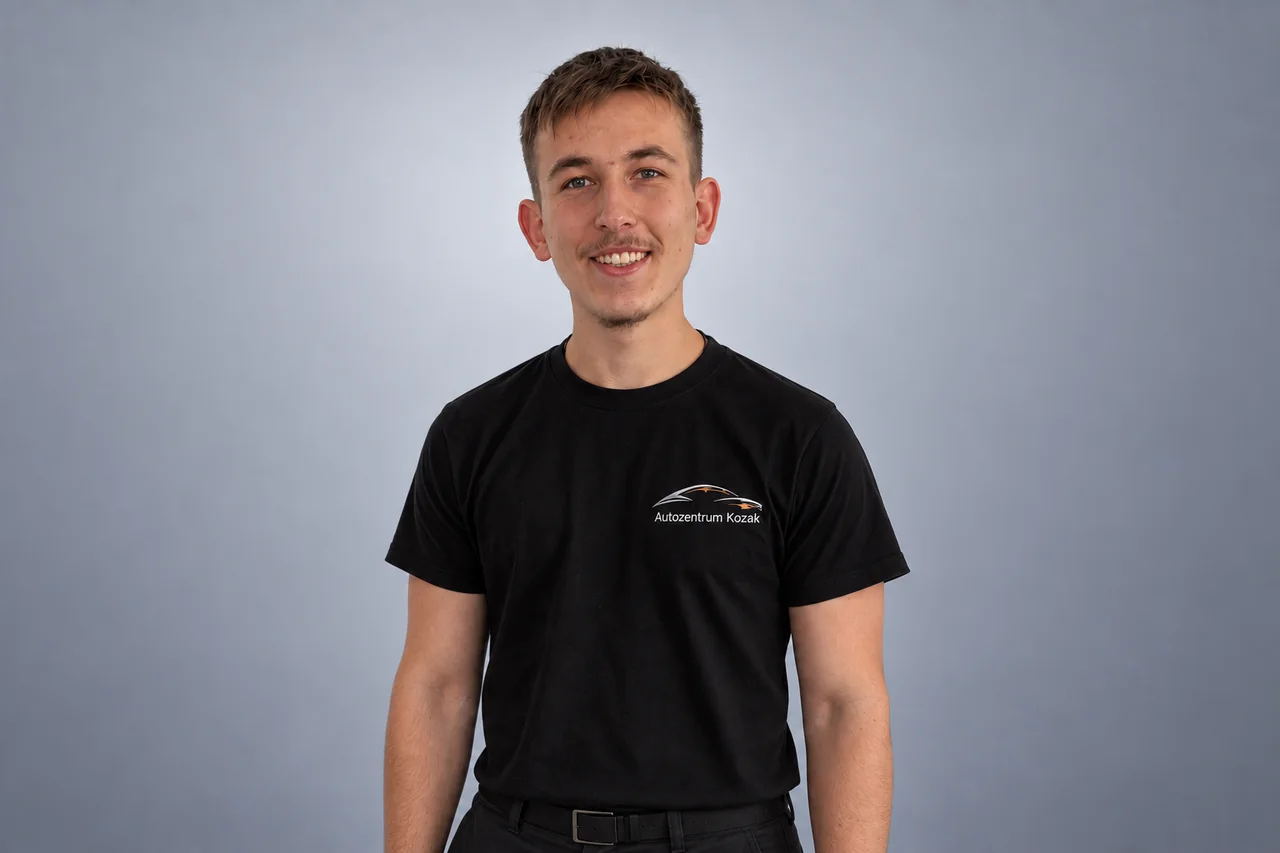 Mitarbeiterin oder Mitarbeiter des Autozentrums Kozak im schwarzen Firmenshirt