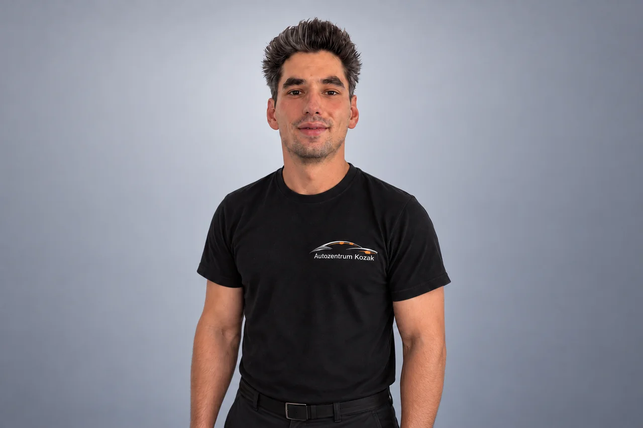 Mitarbeiterin oder Mitarbeiter des Autozentrums Kozak im schwarzen Firmenshirt