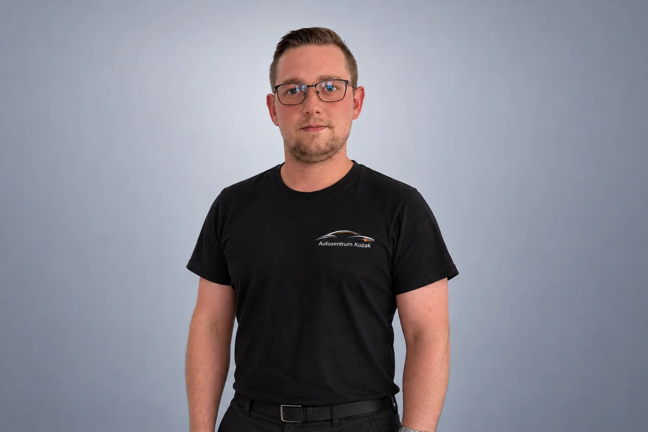Mitarbeiterin oder Mitarbeiter des Autozentrums Kozak im schwarzen Firmenshirt