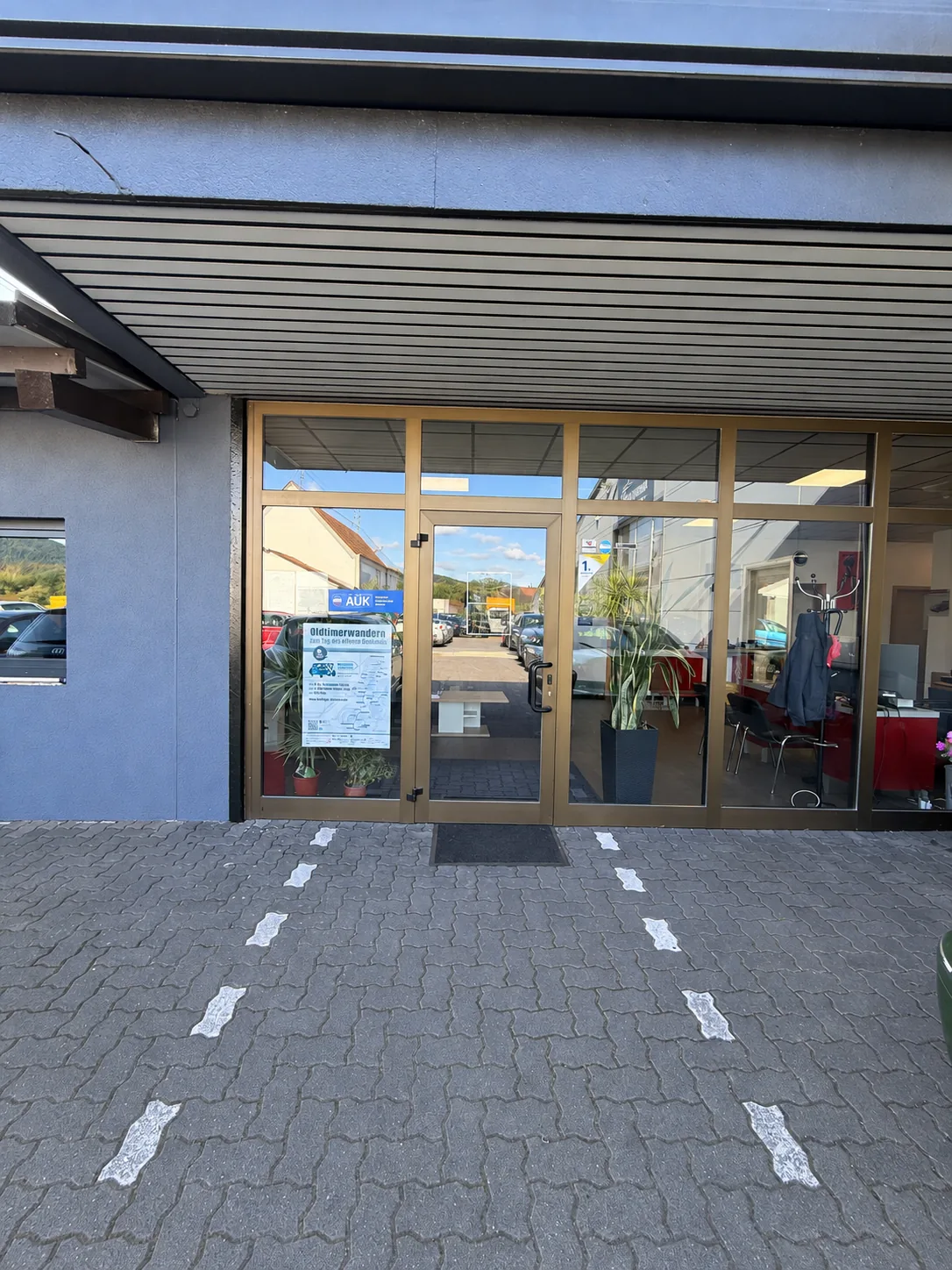 Eingangstür zum Empfang des Autozentrums Kozak mit Parkmarkierungen davor